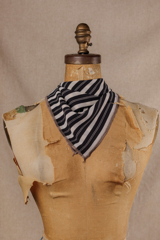 A black and white stripe bandana worn around the neck of a mannequin