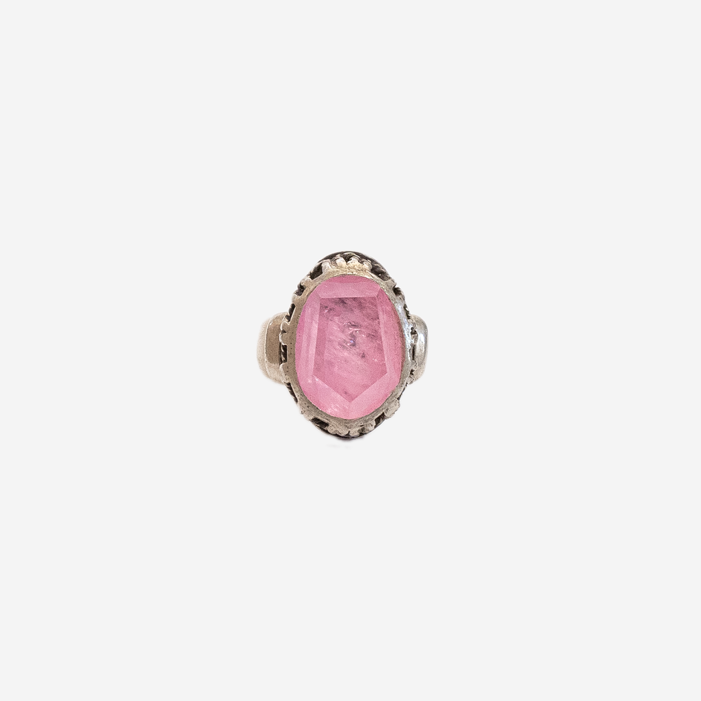 front view of a silver ring with a large pink geometric stone