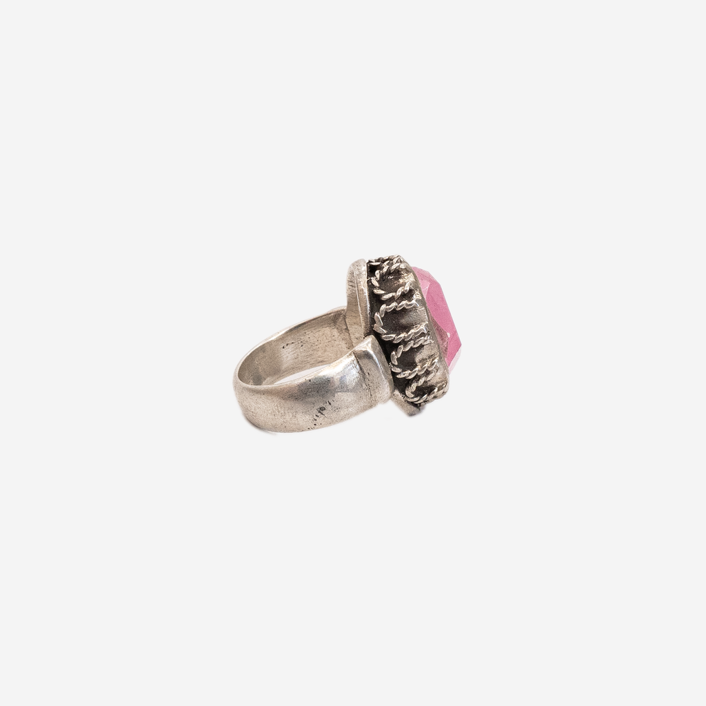 side view of a silver ring with a large pink geometric stone