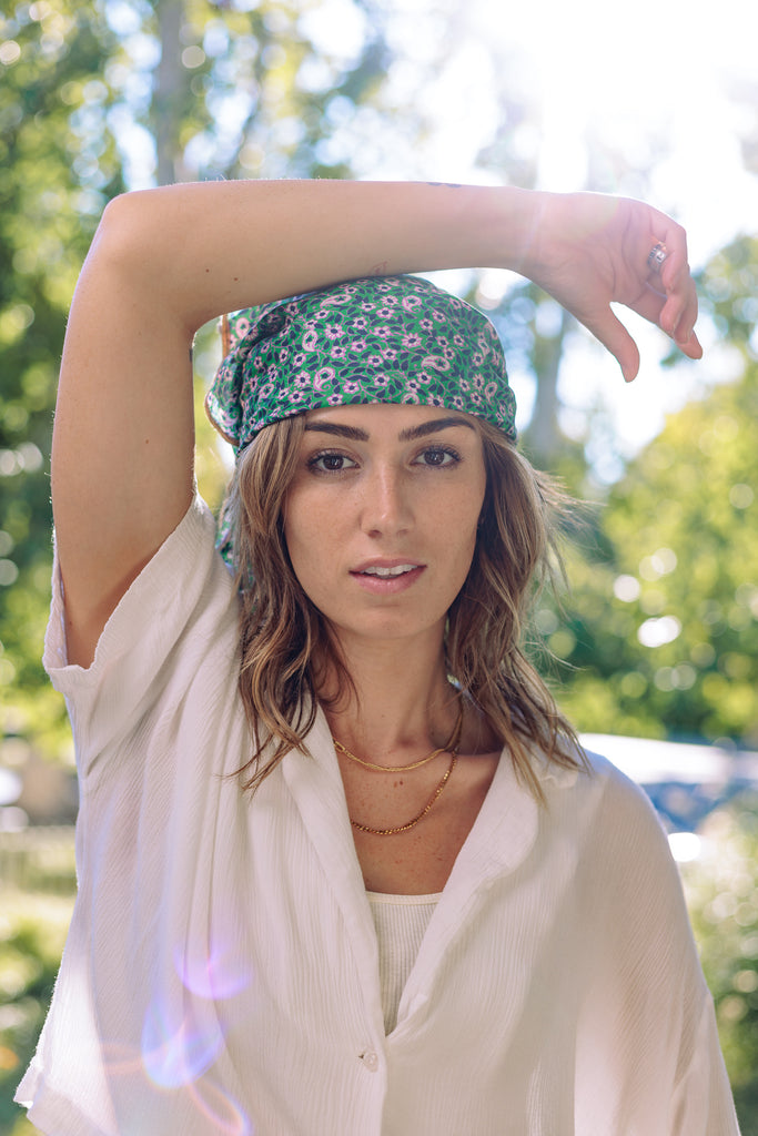 a woman wearing a green floral bandana around her head