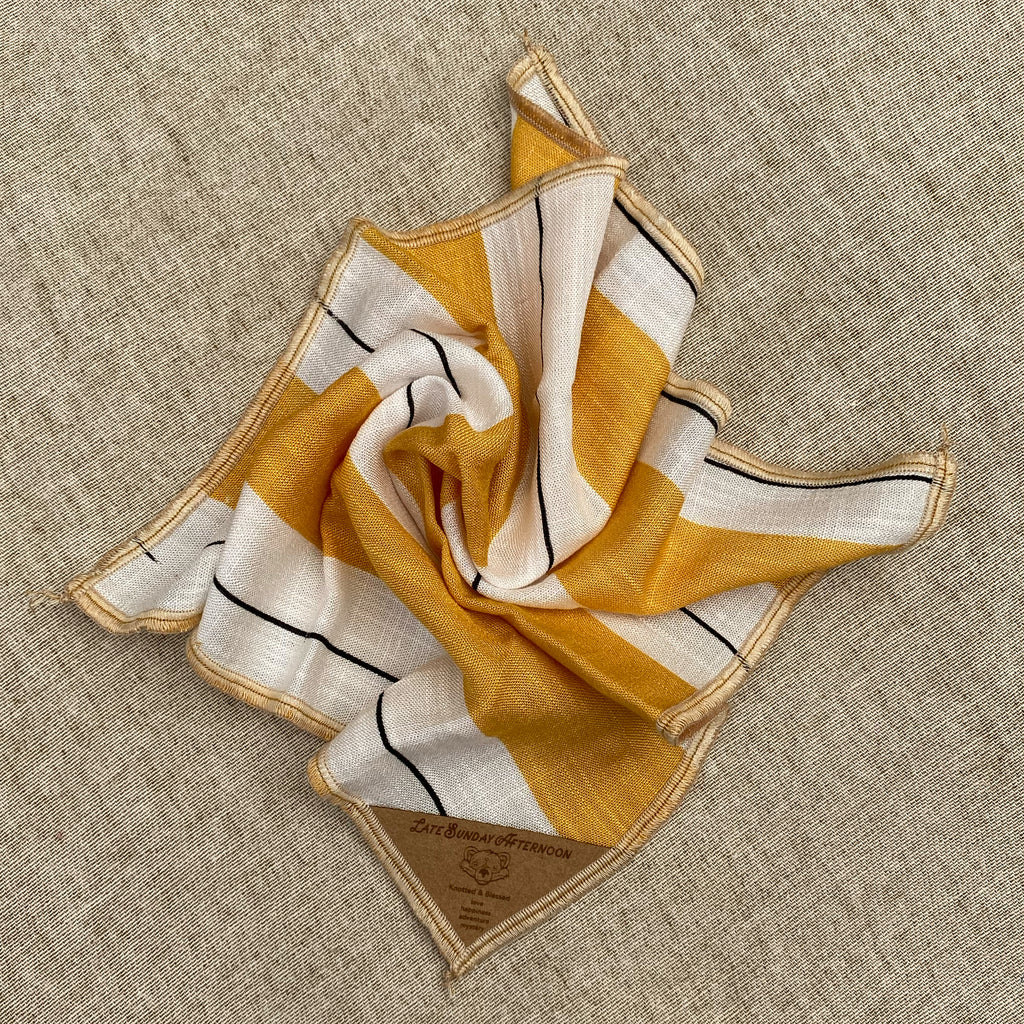 an open pocket square showing thick honey yellow and thin black stripe motif on a white background
