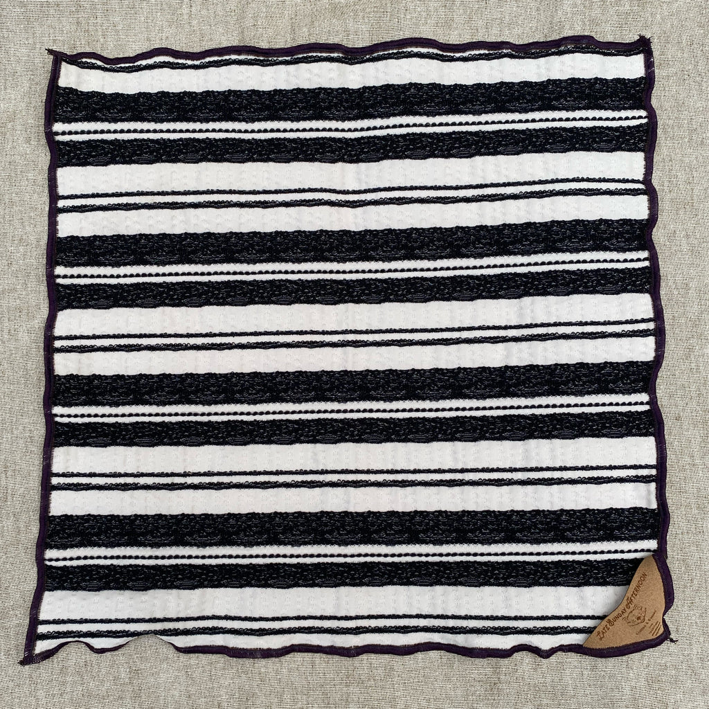 one side of a reversible handkerchief showing a black and white stripe motif