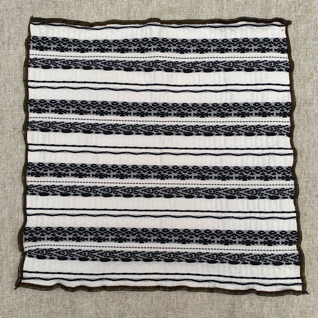 one side of a reversible handkerchief showing an eclectic black and white stripe motif